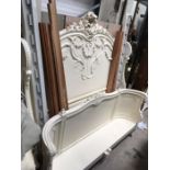 A French style white painted bed, with winged floral moulded headboard and bowed footboard, with