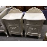 A pair of painted bedside cabinets, with moulded floral frieze and floral swags, fitted drawer
