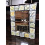 A Piccolpasso tiled wall mirror by Caroline Egleston, 45cm x 36cm, signed verso, together with two