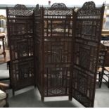 An Indonesian intricately carved hardwood four fold screen, arched top panel decorated with birds