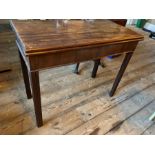 A George III mahogany games table, reeded legs, folding top to reveal a green baize lined surface,