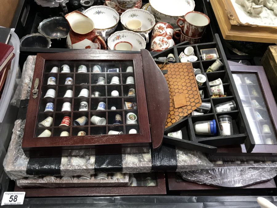 A large collection of thimbles and display cases,