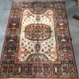 A woven wool rug with central floral medallion on ivory floral patterned ground within geometric