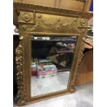 A Regency style gilt framed wall mirror, beveled plate within moulded frame decorated with floral