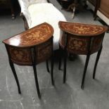 A pair of marquetry inlaid Demi-lune side tables, fitted three drawers, on ormolu mounted ebonised
