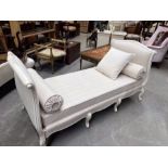 A French style daybed, the white painted frame with moulded floral decoration, on eight cabriole