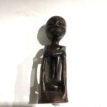 An African tribal carved wood figure, stylized seated figure with crossed arms, 32cm