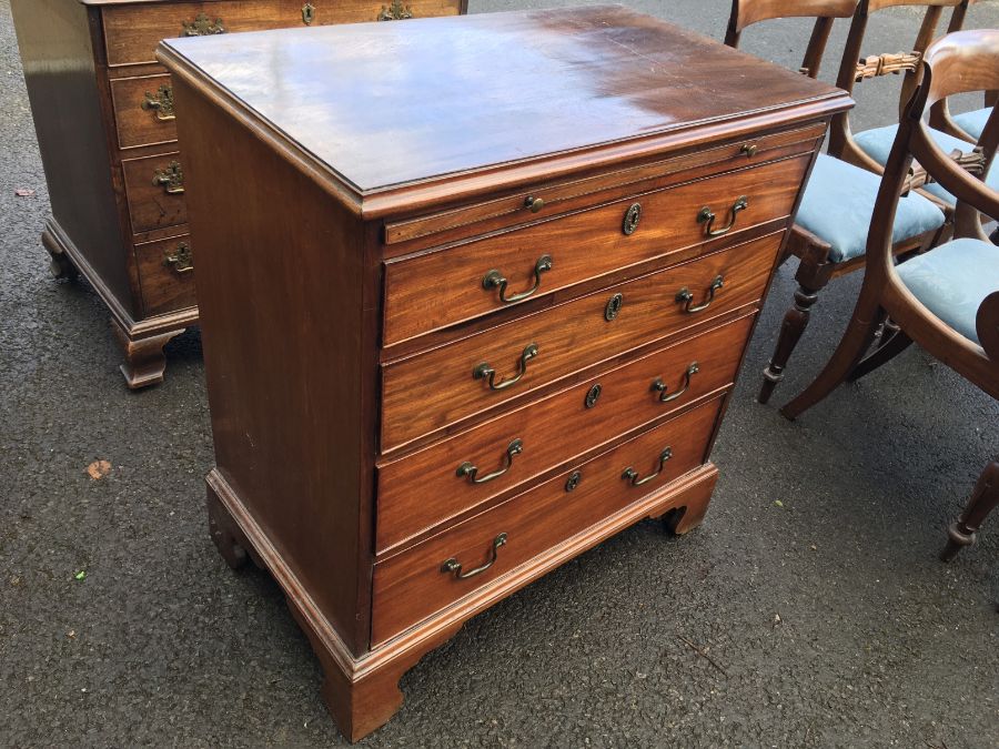 A George III mahogany chest of four graduated cockbeaded drawers, of small proportions, with