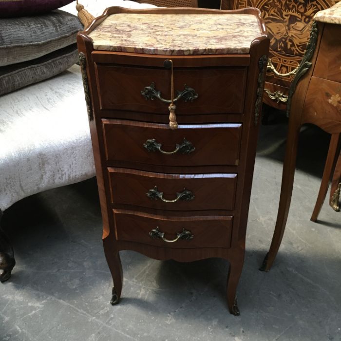 A French marble top chest of five small drawers, with tooled leather brushing slide, ormolu mounts