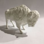 A Coalport blanc de chine figure of a bison, together with a parian figure of a fruit boy, 28cm high