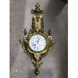 A gilt metal Lava wall clock, in the French 1880's style surmounted by a flaming urn finial, 63cm