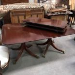 A Regency style mahogany D end twin pedestal extending dining table, on column supports with four