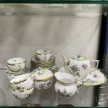 A Herend part tea service, hand painted with peony and butterfly design, with riven rattan moulded