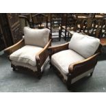 A pair of carved oak framed bergere armchairs, acanthus carved out swept arms with carved from