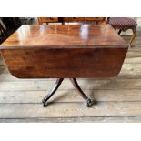 A Regency mahogany Pembroke table, circa 1820, curved end flaps, sabre legs, brass paw cappings