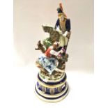 A Continental porcelain figure group, solider and grape picker, on circular socle base, 42cm high