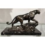 An Art Deco bronzed art metal figure of a panther striding up a rocky outcrop, on marble base,
