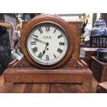 A GWR oak cased clock painted circular dial flanked by foliage scrolls on plinth base 35cm high,