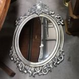 A Whinfield Mirror, oval beveled glass within a moulded foliate scroll and shell moulded frame,