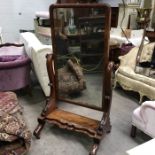 A Victorian mahogany cheval mirror, C scroll supports on ogee shaped stepped platform and scroll
