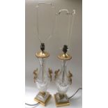 A pair of cut glass lamp bases, baluster form with gilt metal swan handles, on square gilt metal