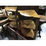 A pair of Art Deco walnut veneered three shelf side tables on block supports. 50cm high. (2)