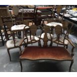 An Edwardian mahogany and marquetry inlaid crown back salon suite, comprising twin-seat sofa and six