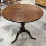 A George III mahogany tilt-top table on turned column and swept tripod supports 78cm diameter