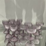 A part suite of moulded purple glass goblets and pedestal dishes, frosted and modelled with floral