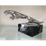 A chromed Jaguar car mascot, on marble base