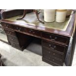 A reproduction twin pedestal desk with green tooled leather writing surface, fitted three drawers