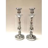 A pair of silvered metal candlesticks with faceted pressed glass drops, 47cm high (2)