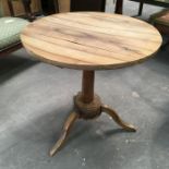 A yew wood circular occasional table, cylindrical column on circular base and three shaped supports,