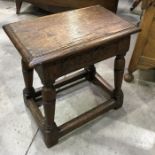 An antique carved oak joint stool, on turned supports and block stretchers 44cm wide