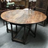 A Georgian oak gateleg table, late eighteenth century, the planked oak top with stub tenons to the