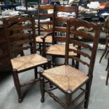 A pair of rush seated country oak ladder back armchairs, together with two similar single chairs (4)