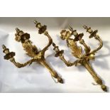A pair of French style gilt metal three branch wall appliques, each with a ribbon crest and tapering