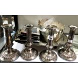 A collection of plated wares including a set of four candlesticks, monteith, four photograph