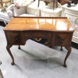 A mahogany and walnut veneered kneehole dressing table, fitted three drawers on cabriole supports,