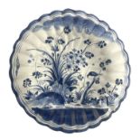 A large Delft blue and white lobed charger, Hanau, circa 1720, ogee section, painted with a bird