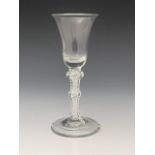 A triple knopped opaque twist wine glass, circa 1765, the bell shaped bowl on a multi strand