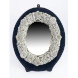 A Continental porcelain framed oval mirror, late 19th Century, florally encrusted branch design in