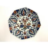 A Dutch Delft polychrome dish, in the Imari palette, octagonal section reeded form, painted with a