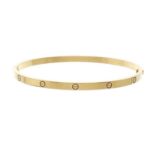 Cartier, an 18ct gold Love bangle bracelet, with screw head motif highlights, signed Cartier, serial