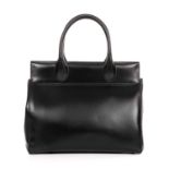 Alaia, a smooth black leather handbag, featuring rolled leather handles, magnetic closure, pale pink
