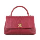 Chanel, a Coco Handle python handbag, crafted from pink python skin, featuring brushed gold-tone