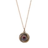 A late Victorian 15ct gold garnet cabochon swirl pendant, with vacant glazed reverse, suspended from