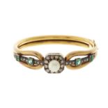 A late 19th century gold, pearl, emerald and rose-cut diamond hinged bangle, pearl measures