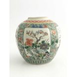A Chinese famille verte ginger jar, decorated with panels of floral specimens within a speckled