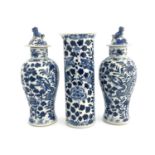 A Chinese blue and white three piece garniture, the two baluster vases with lids, central sleeve